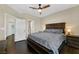 Cozy bedroom with dark wood floors, a ceiling fan, and access to the bathroom at 2050 W Warm Springs Rd # 823, Henderson, NV 89014