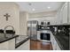 Modern kitchen featuring stainless steel appliances, black countertops, and ample cabinet space at 2050 W Warm Springs Rd # 823, Henderson, NV 89014