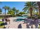 Community pool area with a bridge, palm trees, lounge chairs, umbrellas, and a spa at 2050 W Warm Springs Rd # 823, Henderson, NV 89014