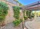 Backyard patio area with a covered pergola, rock landscaping, and mature foliage at 2138 Grand Traverse St, Henderson, NV 89052