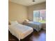 Cozy bedroom featuring twin beds, hardwood floors, and a bright window at 2138 Grand Traverse St, Henderson, NV 89052