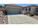 Single story home with a two car garage and a beautiful desert landscape in the front yard at 2138 Grand Traverse St, Henderson, NV 89052