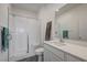 Modern bathroom with glass-enclosed shower, white vanity, and dark gray tile flooring at 226 White Crest Peak Ave, Henderson, NV 89015