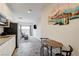 A small kitchen with stainless steel appliances is beside a table and living space at 226 White Crest Peak Ave, Henderson, NV 89015