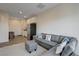 Open concept living room featuring a gray sectional couch and adjacent kitchen area at 226 White Crest Peak Ave, Henderson, NV 89015