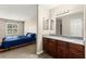 Spacious bedroom next to a bathroom featuring a dark wood vanity with granite countertop and a well-lit mirror at 2606 S Durango Dr # 245, Las Vegas, NV 89117