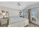 Bright bedroom with a white wooden bed frame, ceiling fan, and access to a balcony at 2684 Korea Ct, Henderson, NV 89052