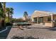 Landscaped backyard boasts a gravel area, mature trees, and a covered patio offering a serene and private outdoor space at 2713 Tanagrine Dr, North Las Vegas, NV 89084