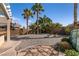 The backyard offers a gravel and stone landscape with mature trees, a built-in BBQ, and a cozy seating area at 2713 Tanagrine Dr, North Las Vegas, NV 89084