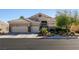 Charming single-story home featuring a three-car garage, desert landscaping, and a tile roof at 2713 Tanagrine Dr, North Las Vegas, NV 89084