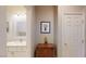 Hallway leading to a bathroom with a vanity, mirror, and cabinet with decor at 2713 Tanagrine Dr, North Las Vegas, NV 89084
