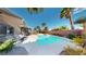 Backyard features a refreshing pool, lush palms, lounge chairs, and a covered patio, perfect for outdoor relaxation and entertaining at 2713 Tanagrine Dr, North Las Vegas, NV 89084