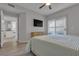 Bright bedroom with light wood floors, a ceiling fan, and a dresser beneath a wall-mounted television at 2900 Sunridge Heights Pkwy # 1916, Henderson, NV 89052