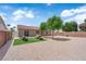 The backyard features desert landscaping with turf, mature trees, and a cozy seating area perfect for entertaining at 3102 Honeysuckle Ave, North Las Vegas, NV 89031