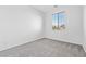 Bright bedroom features neutral paint, gray carpet, and window providing natural light at 3273 Alcudia Bay Ave, Las Vegas, NV 89141