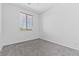 Bright bedroom features neutral paint, gray carpet, and window providing natural light at 3273 Alcudia Bay Ave, Las Vegas, NV 89141