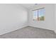 Bright bedroom features neutral paint, gray carpet, and window providing natural light at 3273 Alcudia Bay Ave, Las Vegas, NV 89141