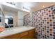 Bathroom with double sinks, a large mirror, and a shower with a colorful patterned curtain at 3728 Juanita May Ave, North Las Vegas, NV 89032