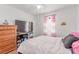 Bright and airy bedroom featuring a ceiling fan, large TV, and cozy bedding at 3821 E Summit Ave, Pahrump, NV 89061