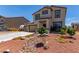 Charming two-story home with a three-car garage, desert landscaping and a small bridge feature at 3821 E Summit Ave, Pahrump, NV 89061