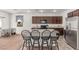 Modern kitchen features a breakfast bar, dark wood cabinets, stainless steel appliances, and backyard access at 3821 E Summit Ave, Pahrump, NV 89061