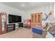 Neutral living room featuring a wood china cabinet, grandfather clock and mounted television at 3821 E Summit Ave, Pahrump, NV 89061