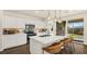 Modern kitchen featuring stainless steel appliances, white cabinetry, an island with bar seating, and outdoor views at 4140 E Brusca Way, Pahrump, NV 89061