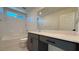 Bright bathroom features a shower-tub combo with gray vanity and white countertop at 4705 Parkarbor Ave, Las Vegas, NV 89141