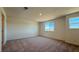 Large bedroom with carpet flooring, two windows allowing natural light, and neutral walls at 4705 Parkarbor Ave, Las Vegas, NV 89141