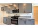 Modern kitchen featuring gray cabinets, granite countertops, and stainless steel appliances at 4705 Parkarbor Ave, Las Vegas, NV 89141