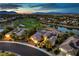 Panoramic aerial view showcasing a luxury home with a golf course and city skyline in the background at dusk at 5162 Estasi St, Las Vegas, NV 89135
