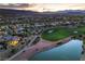 Desert home near golf course with pond, lush landscaping, desert plants, and mountain views at 5162 Estasi St, Las Vegas, NV 89135