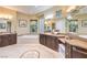 Luxurious bathroom featuring dual vanities, a soaking tub, and elegant tile flooring at 5162 Estasi St, Las Vegas, NV 89135