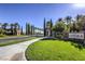 Scenic community entrance with lush greenery, stone signage, and elegant guard houses under a clear blue sky at 5162 Estasi St, Las Vegas, NV 89135