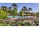 Resort-style pool area with lounge chairs, shade structures, and mature palm trees within a gated community at 5162 Estasi St, Las Vegas, NV 89135