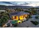 Desert home featuring a private pool, covered patio, lush greenery, and secure fencing, ideal for relaxation and privacy at 5162 Estasi St, Las Vegas, NV 89135