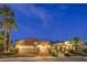 Warm exterior view of home with three-car garage, palm trees, and manicured landscaping at dusk at 5162 Estasi St, Las Vegas, NV 89135