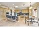 Bright kitchen with stainless steel appliances, large island with bar stools, and breakfast nook with round glass table at 5162 Estasi St, Las Vegas, NV 89135
