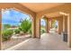 Covered outdoor patio with stone flooring and arches, overlooking the manicured backyard at 5162 Estasi St, Las Vegas, NV 89135
