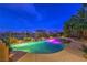 Twilight view of pool surrounded by lush landscaping and a wrought iron fence at 5162 Estasi St, Las Vegas, NV 89135