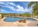 Swimming pool features natural rock border, lush landscaping, and views of the surrounding desert landscape at 5162 Estasi St, Las Vegas, NV 89135