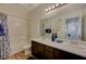 Bathroom with double sink vanity, shower-tub combo, and decorative flower arrangement at 5244 Fiery Sky Ridge St, Las Vegas, NV 89148