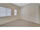 Neutral bedroom featuring two windows with blinds and a white interior door at 5244 Fiery Sky Ridge St, Las Vegas, NV 89148