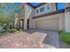 Two-story home with a two-car garage, brick paved driveway, and well-kept landscaping in front at 5244 Fiery Sky Ridge St, Las Vegas, NV 89148