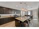 Well-lit kitchen with dark cabinets, granite countertops and stainless steel appliances overlooking the dining area at 5244 Fiery Sky Ridge St, Las Vegas, NV 89148