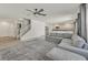 Bright living room with a ceiling fan, open staircase, and a large gray sectional sofa at 5250 Chester Creek Ct, Las Vegas, NV 89141