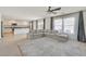 Open-concept living space with a gray sofa, large windows, and an adjacent kitchen with granite counters at 5250 Chester Creek Ct, Las Vegas, NV 89141