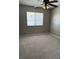 Neutral bedroom with plush carpet, ceiling fan, and a window providing natural light at 5389 Spencer St, Las Vegas, NV 89119