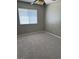 Bright bedroom featuring neutral carpet, paint, and a window providing natural sunlight and a ceiling fan at 5389 Spencer St, Las Vegas, NV 89119