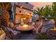Beautiful backyard setting with outdoor kitchen, fire pit, and cozy seating, perfect for relaxing evenings at 5779 Baffy Cir, Las Vegas, NV 89142